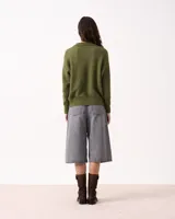 Sweater de punto color rosado, con cuello polo y escote en V. Tiene manga larga con puños ajustados y ruedo en punto ajustado.