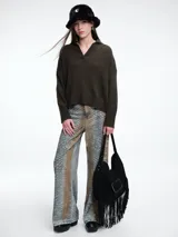 Sweater de punto color verde oliva, con cuello polo abierto en V, manga larga con hombros caídos y terminaciones acanaladas en puños y ruedo.