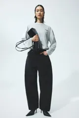 Top oversized de punto de algodón suave en color gris melange, con diseño estampado de letras pequeñas en el pecho. Presenta manga larga, cuello redondo ribeteado y hombros caídos.