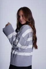 Sweater Bremer con cuello redondo y mangas largas ligeramente amplias. Diseño a rayas horizontales en color crudo y negro.