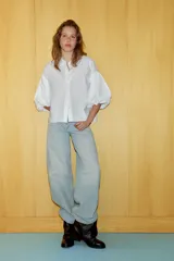 Camisa de algodón con cuello solapa y cierre frontal con botones ocultos. Presenta mangas abullonadas por debajo del codo con terminación elástica.