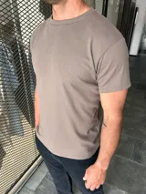 Remera de manga corta y cuello redondo, color marrón topo, de corte clásico.