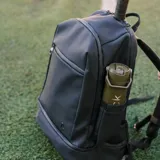 Mochila deportiva negra de diseño minimalista, con múltiples compartimentos, incluyendo espacio térmico para raquetas, bolsillo inferior ventilado para calzado y compartimento interno para laptop.