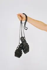 Sandalias negras de cuero sintético con tiras finas que se atan al tobillo.