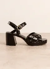 Sandalias de taco ancho y plataforma, color negro charol, con tiras cruzadas en el empeine y tira ajustable con hebilla en el tobillo.
