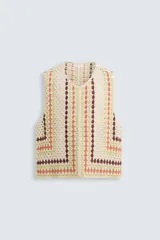 Chaleco de punto crochet con cuello pico y sisa, tejido en bloques de color beige, verde claro, naranja y marrón oscuro.