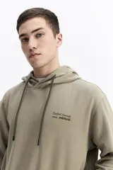 Canguro con capucha y cordones ajustables, de corte holgado y bolsillo frontal tipo canguro. Presenta un pequeño logo estampado en el pecho.