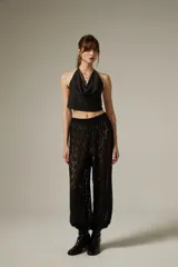 Pantalón tipo babucha de encaje color crudo, con corte holgado y cintura elástica.