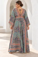 Vestido largo de estilo bohemio, color azul con estampado floral en tonos blancos y detalles geométricos en el escote y la cintura. Posee escote en V con cordones ajustables, mangas amplias tipo kimono y una silueta fluida y holgada.