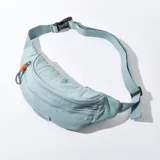 Riñonera celeste de tela con correa ajustable y cierre con hebilla.