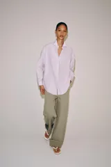 Camisa de manga larga confeccionada en hilatura con mezcla de algodón, con cuello solapa, bajo redondeado y cierre frontal oculto con botones.