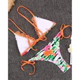 Bikini de dos piezas con estampado floral y de rayas, con detalles en color naranja. El corpiño es de corte triangular con tiras regulables y bordes con apliques decorativos, y la bombacha es tipo tanga con tiras laterales para atar.