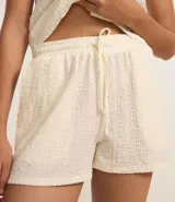 Bermuda de mujer confeccionada en tejido chambray texturizado, con corte recto, cintura elástica y lazo de ajuste.