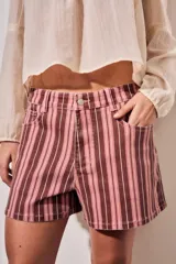 Short de tiro alto confeccionado en denim con diseño a rayas en tonos rosados, borravino y blancas. Cuenta con bolsillos delanteros y traseros, presillas para cinto y cierre frontal con botón metálico y cremallera.