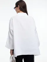 Camisa de lino roja con silueta amplia y mangas 3/4. Diseño con tiras de color rosa en contraste en la cartera, mangas y cuerpo. Tiene tajos laterales y ruedo irregular en el frente.