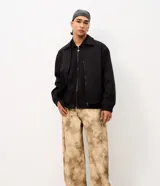 Pantalón de gabardina de algodón Blue Steel, modelo Super Baggy, con diseño amplio y estampa abstracta con efecto manchado en tonos marrón y beige. Cuenta con cintura con presillas, cierre de botón y cremallera, y bolsillos funcionales.