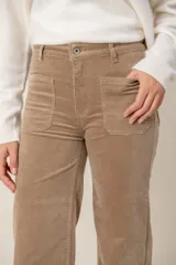 Pantalón de corte recto confeccionado en pana color beige, con bolsillos delanteros tipo parche y cierre frontal con botón.