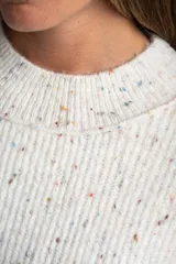 Sweater de tejido de punto color blanco roto con efecto tweed o confeti, caracterizado por pequeñas motas de colores. Presenta cuello redondo y un calce holgado (oversize).