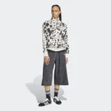 Campera deportiva Adidas de satén con estampado animal print, cuello alto, cierre frontal y las icónicas tres tiras a lo largo de las mangas.