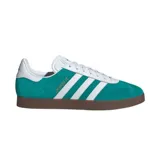 Championes adidas Gazelle edición especial Liverpool FC, color verde esmeralda con las icónicas tres tiras blancas laterales y suela de goma color marrón. Presenta el detalle del nombre del club en letras doradas sobre el lateral.