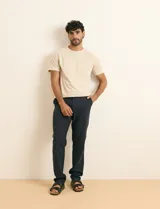 Remera básica de algodón color beige, de manga corta, con cuello redondo y un pequeño detalle bordado en el pecho.