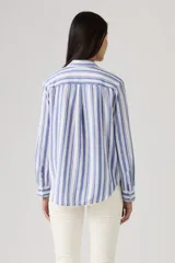 Camisa de manga larga con diseño de rayas verticales en tonos azul y blanco, cuello camisero, cierre frontal y dos bolsillos delanteros con solapa.