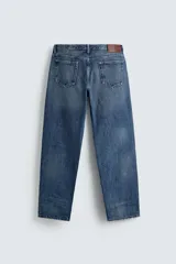 Jeans de corte recto en tono azul clásico con efecto lavado, tiro medio y diseño de cinco bolsillos con cierre frontal de botones.
