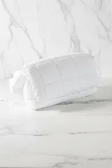 Cartera tipo bandolera acolchada de color verde brillante, con correa ancha y ajustable con hebilla metálica.