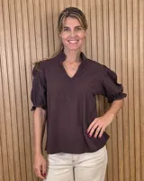 Blusa marrón oscura de manga corta abullonada con puños elastizados, escote en V y cuello alto con volados.
