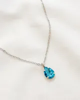 Collar plateado con dije de cristal celeste en forma de lágrima.