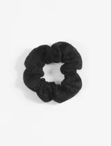 Gomita de pelo negra con hilos de lurex plateados.