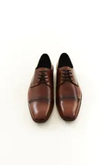 Zapato de vestir acordonado de cuero vacuno marrón, con puntera distinguida y suela con sutil tacón.