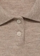 Jersey de punto fino con diseño de rombos, cuello polo con cierre de botones y manga corta.