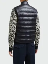 Chaleco de plumas Moncler modelo Gui, color azul marino, con diseño acolchado, cierre frontal con cremallera y cuello alto. Presenta el logo de la marca en el pecho.