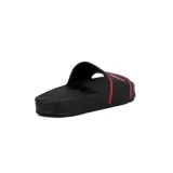 Chancletas tipo slide negras con tira ancha que presenta el logo Fila en rojo, bordeado por una línea roja. La plantilla es texturada.