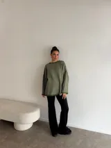 Pantalón tipo oxford de tiro alto, color negro, con corte ajustado en la parte superior y acampanado desde la rodilla hacia abajo.