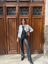 Chaqueta dorada metalizada con cuello camisero, cierre frontal con botones y bolsillos de parche en el pecho.