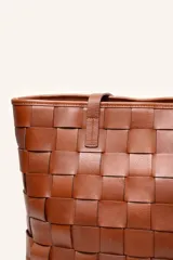 Cartera tipo tote de cuero marrón, confeccionada con diseño trenzado artesanal y doble asa de hombro.
