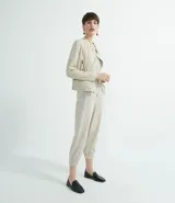 Pantalón estilo jogger de suedine, con cintura elástica y cordón ajustable, puños elásticos en los tobillos, bolsillos laterales y detalles perforados en los laterales y bolsillos.