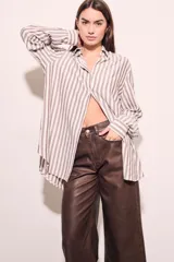 Camisa oversize a rayas verticales color beige y blanco, de mangas largas y corte holgado.