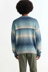 Sweater de tejido de punto con diseño degradé en tonos azules y beige, de corte holgado, cuello redondo y mangas largas.