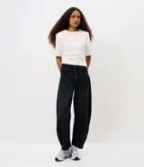 Pantalón baggy balloon de jean negro, con cintura media, cierre frontal con fila de botones y bolsillos funcionales.