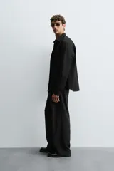 Camisa blanca de manga larga con cuello italiano y cierre frontal de botonadura. Corte regular fit.