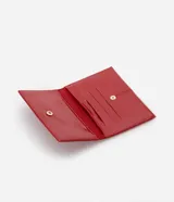 Billetera de mano Satinato tipo sobre, de color rojo con acabado barnizado y costuras decorativas. Cuenta con cierre de botón a presión.