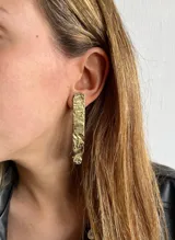 Aros colgantes largos de bronce con textura irregular.