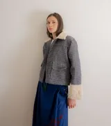 Chaqueta de jacquard con diseño a cuadros, cuello y puños de piel sintética, cierre frontal y bolsillos laterales.