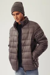 Campera puffer de invierno color azul marino, con cuello elevado, cierre frontal completo y capucha oculta. Presenta bolsillos laterales con cierre y logo en relieve en el pecho.