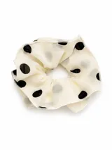 Gomita para el pelo tipo scrunchie de tela ligera color crema con estampado de lunares negros.