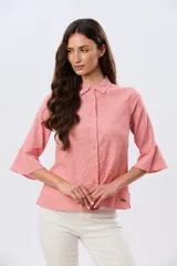 Camisa de lino celeste con cuello clásico, cierre frontal con botones y mangas tres cuartos terminadas en volados.