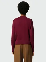 Cárdigan de lana color borgoña con cuello redondo, cierre frontal con botones y logo bordado en el pecho. Corte clásico.